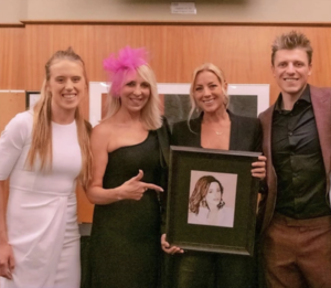 From left to right: Athena Hart, Dr. Martha Hart, Sarah McLachlan receiving a drawing made by Oje Hart